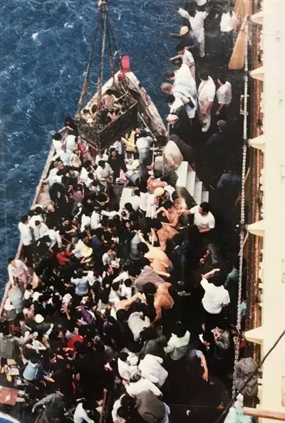 a packed boat being rescued by british cargo ship ss sibonga
